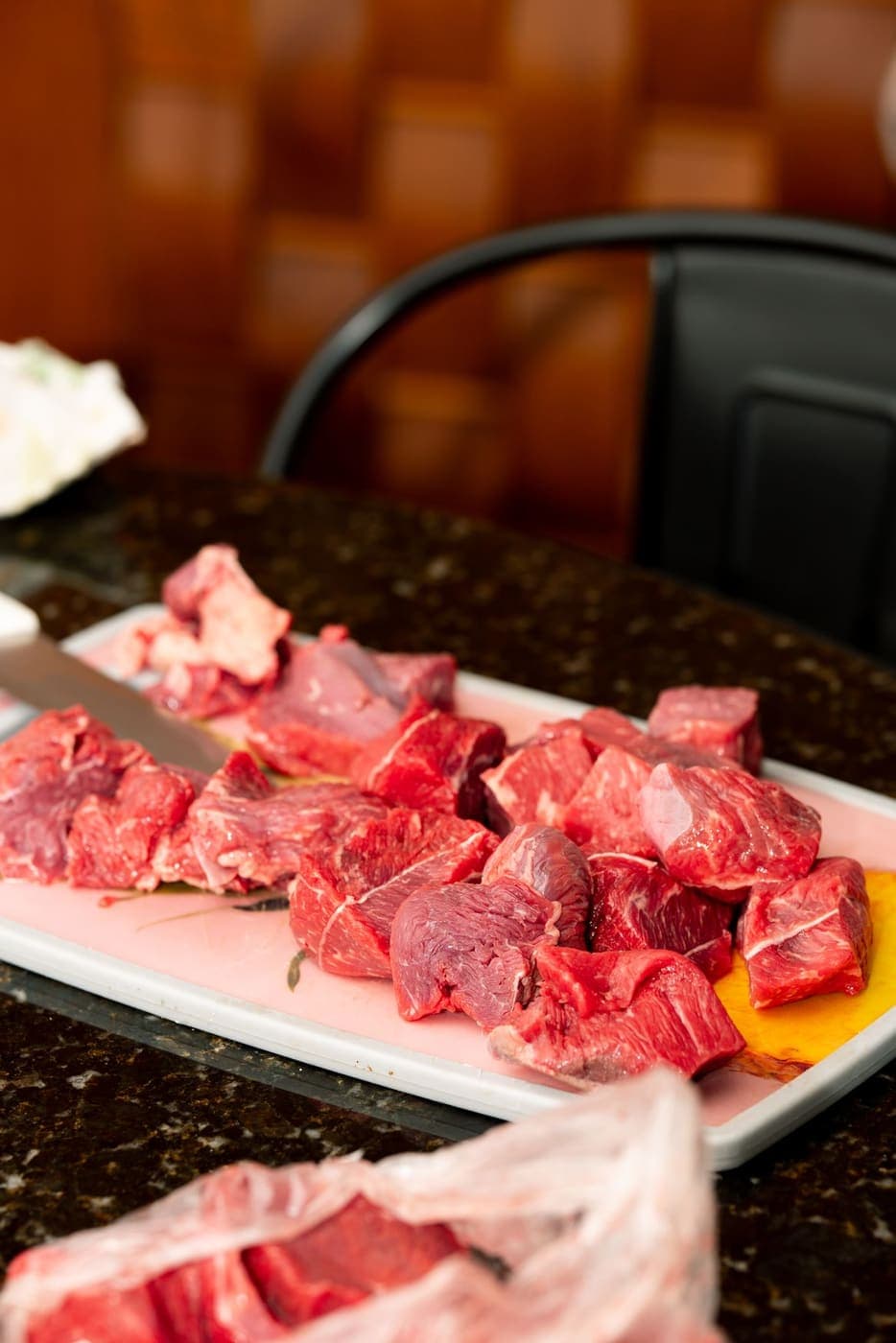 Cubes of raw beef on a white tray